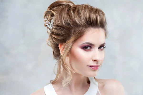 Junge schöne Braut mit einer eleganten hohen Frisur. Hochzeitsfrisur mit Accessoire im Haar — Stockfoto