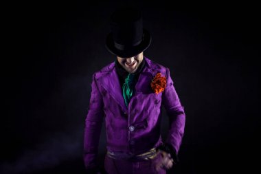 Gizemli adam bir takım, baston, bir silindir. Koyu arka plan. Korkunç ve kötü. Joker, Halloween kılık