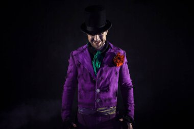 Gizemli adam bir takım, baston, bir silindir. Koyu arka plan. Korkunç ve kötü. Joker, Halloween kılık