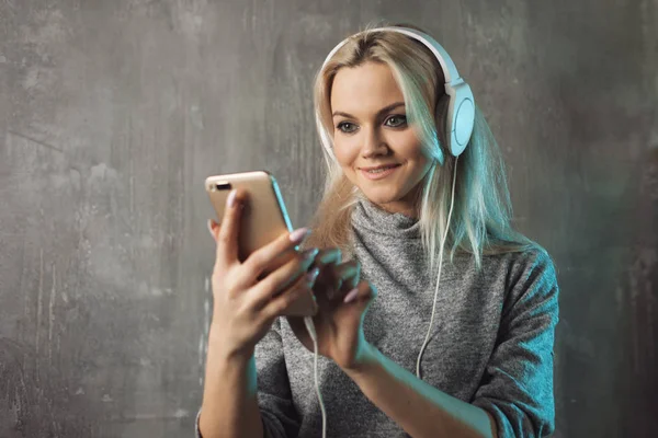 Mujer atractiva feliz y positiva escuchando música en la aplicación móvil. Chica amante de la música . —  Fotos de Stock