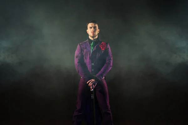 Showman. Young male entertainer, presenter or actor on stage. The guy in the purple camisole and the cylinder.