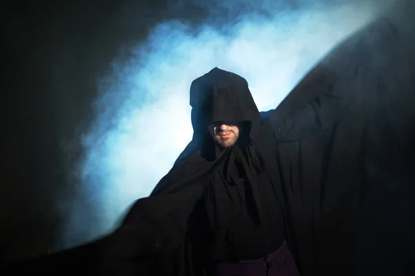 阴沉的形象。穿着黑色斗篷的男人。恶魔般的形象。魔术师魔法师 — 图库照片