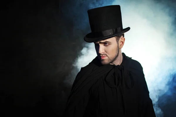 Man in a black top hat and cloak. Demonic image. Magician illusionist — Stock Photo, Image