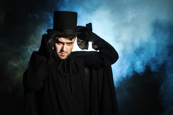 Férfi fekete kalap- és köpenyt. Démoni kép. Bűvész, illuzionista — Stock Fotó