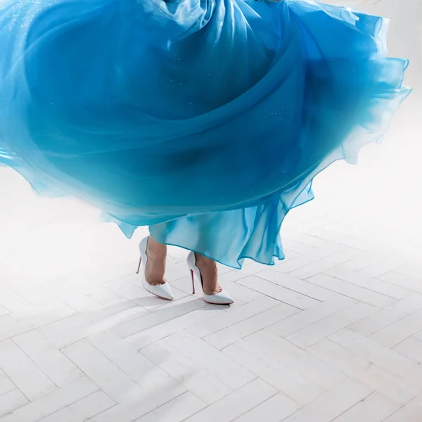 Stijlvolle vrouw voeten in een gezwollen rok en witte schoenen. — Stockfoto