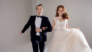 Gülüyor ve birlikte dans olumlu genç bir çift. Çift Studio hafif bir arka plan.