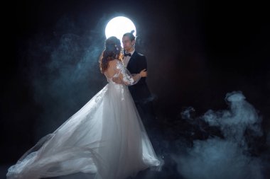 Gizemli ve romantik bir buluşma, gelin ve damat ayın altında. Birlikte sarılmak. Karışık teknik