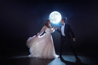 Gizemli ve romantik bir buluşma, gelin ve damat ayın altında. Birlikte sarılmak. Karışık teknik
