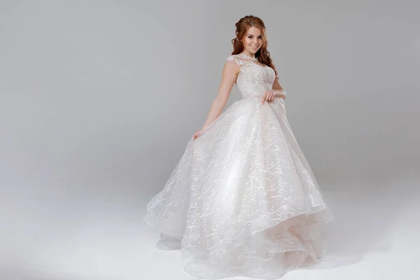 豪華なウェディング ドレスの花嫁を素敵な若い女性。明るい背景. — ストック写真
