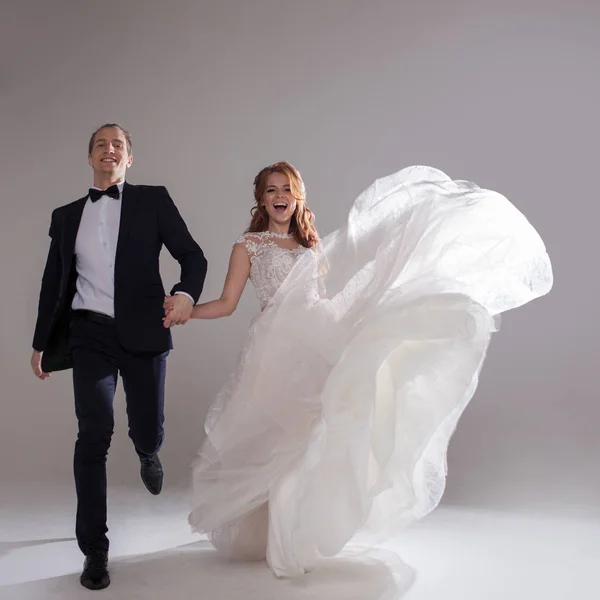 Felizes juntos. Casal jovem positivo rindo e dançando juntos. O casal no Estúdio um fundo leve . — Fotografia de Stock