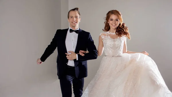 Pareja joven positiva riendo y bailando juntos. La pareja en el Studio un fondo claro . — Foto de Stock