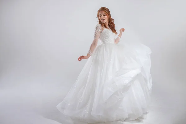 Lovely young woman bride in lavish wedding dress. Light background. — Stock Photo, Image