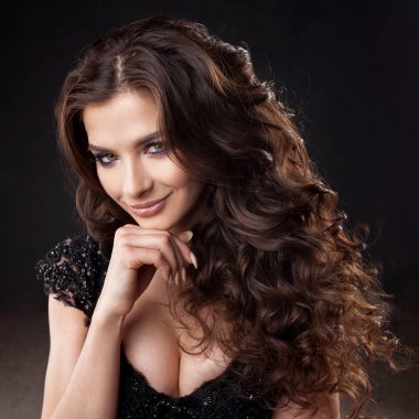 Muhteşem kıvırcık saçlı genç bir çekici kadın portresi. Çekici esmer