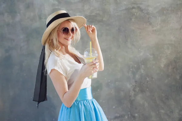 Junge schöne blonde Frau mit Strohhut. Sonnenbrille im Sommer. — Stockfoto