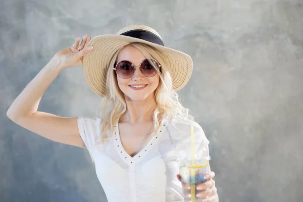 Junge schöne blonde Frau mit Strohhut. Sonnenbrille im Sommer. — Stockfoto