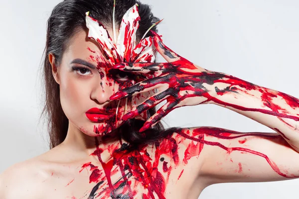 Blood Lily, děsivý a sexy Halloweenský vzhled. Krásná mladá brunetka dívka na bílém pozadí — Stock fotografie
