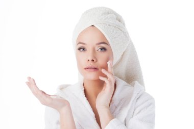 Duştan sonra krem kullanmak için. Bornoz ve havlu başında genç bir çekici kadın portresi.