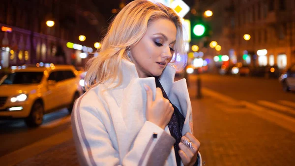 Mujer joven con estilo y elegante en un abrigo beige en la ciudad  . — Foto de Stock