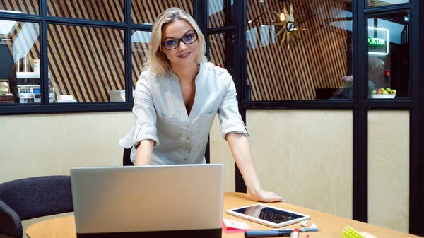 Junge Geschäftsfrau in ihrem Büro. Bei der Arbeit im Büro steht ein professionelles Mädchen mit einem Laptop am Tisch, — Stockfoto