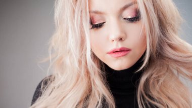 Baştan savma bukleleri olan çekici bir sarışın, yakın plan.