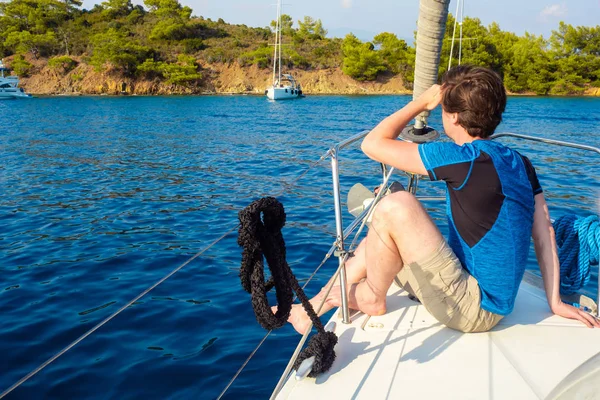 Отдых на море, морская прогулка на яхте. Молодой человек в голубой футболке — стоковое фото