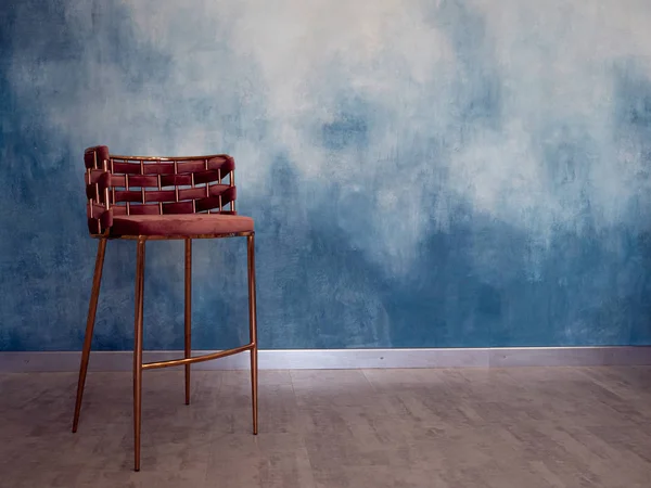 Mavi gölgenin dokulu duvarının arka planında şık bir sandalye., — Stok fotoğraf