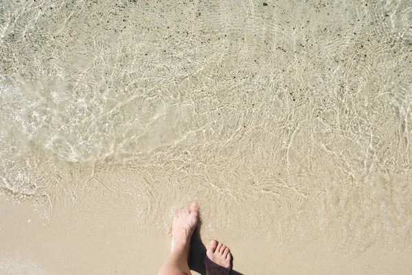 Entra in mare, i piedi delle donne sulla sabbia prima del surf — Foto Stock