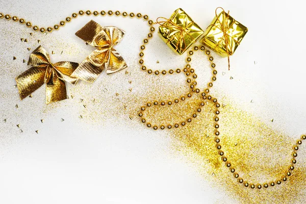 Festlig nyårslägenhet. Guld inredning på vit bakgrund. Mousserande semester bågar pärlor och presentförpackningar — Stockfoto