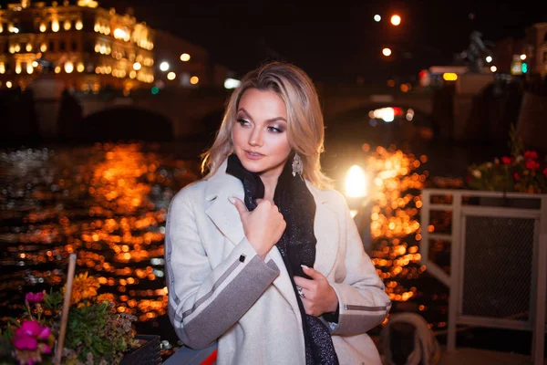 Стильна і елегантна молода жінка в бежевому пальто на міській набережній . — стокове фото