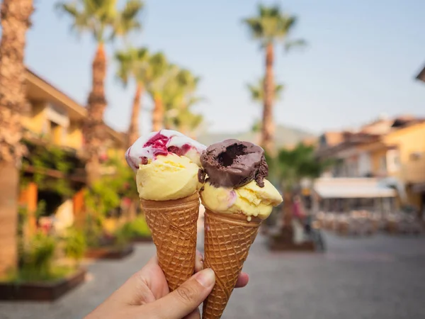 Deux portions de crème glacée dans un cône de gaufre. La fille tient dans sa main de la crème glacée pour deux, crème glacée et sorbet — Photo