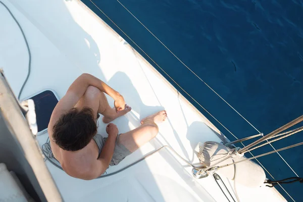 समुद्रावर विश्रांती घ्या, नौकेवर बोट ट्रिप करा. शॉर्ट्समध्ये एक तरुण माणूस — स्टॉक फोटो, इमेज