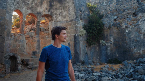 Young man tourist on the background of the ruins of ancient buildings. — Stock Photo, Image