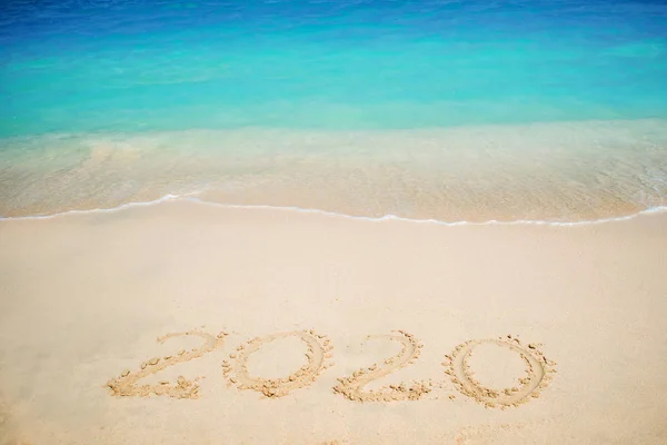 Nuevo 2020 año en el sur, el mar. Surf marino. La ola azul está llegando a tierra. Inscripción en arena , — Foto de Stock