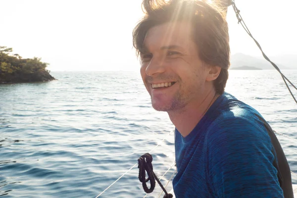 Отдых на море, морская прогулка на яхте. Молодой человек в голубой футболке — стоковое фото