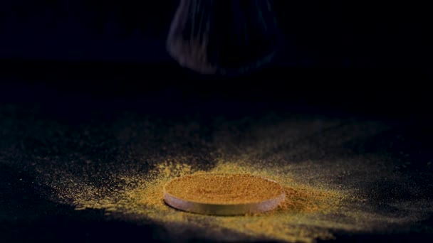 Makeup artists το αφράτο πινέλο μπαίνει σε μια παλέτα σκιών, βουτώντας σε ένα πλούσιο χρυσό χρώμα. — Αρχείο Βίντεο