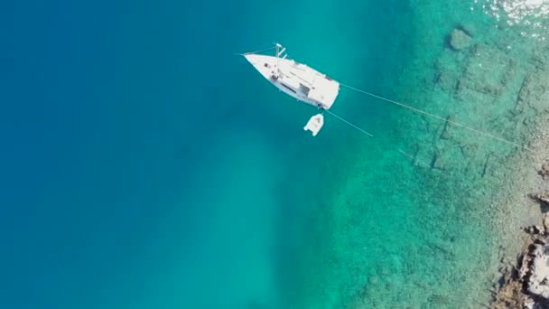 Ιστιοπλοϊκό σκάφος αγκυροβολημένο στην ακτή, ένα ευχάριστο βίντεο drone θαλασσογραφία. — Αρχείο Βίντεο