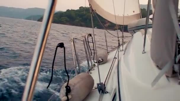 Boottocht op een zeiljacht, een stukje dek en de bergen aan de horizon — Stockvideo