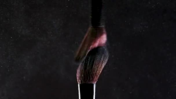 Dwie miękkie szczotki kosmetyczne uwalniają chmurę kolorowego dymu z jasnego cienia do powiek i proszku, — Wideo stockowe