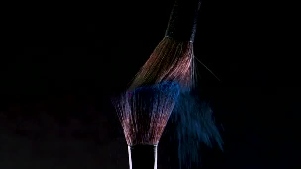 Zwei weiche Kosmetikpinsel setzen eine Wolke aus farbigem Rauch aus hellem Lidschatten und Puder frei, — Stockvideo