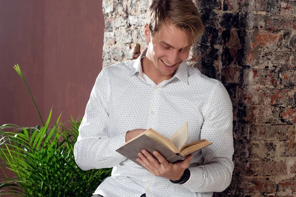 Um jovem de camisa branca a ler um livro. Literatura de negócios para auto-desenvolvimento . — Fotografia de Stock