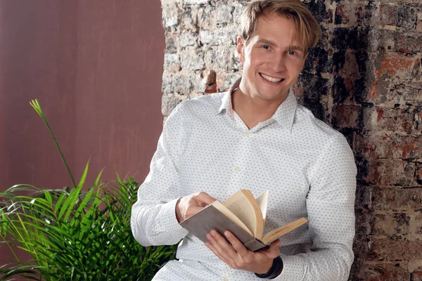 Jovem com uma camisa branca lendo um livro. Literatura empresarial . — Fotografia de Stock