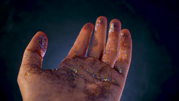 Mano femminile ricoperta di paillettes. Il movimento del palmo della mano e brillare glitter multicolore , — Video Stock