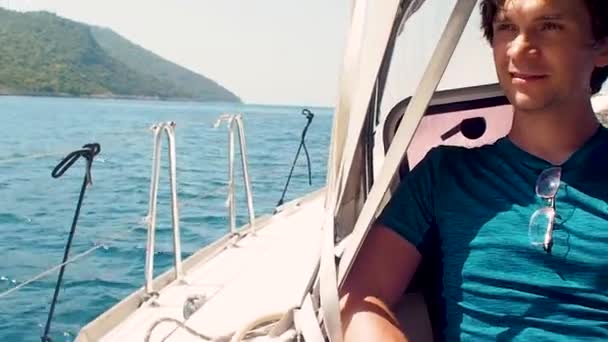 Riposo sul mare, gita in barca su uno yacht. Un giovane uomo in t-shirt blu — Video Stock