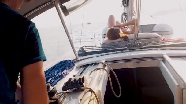 帆の下のヨットでボート旅行、男性ヨットマンはウィンチにロープを巻く — ストック動画