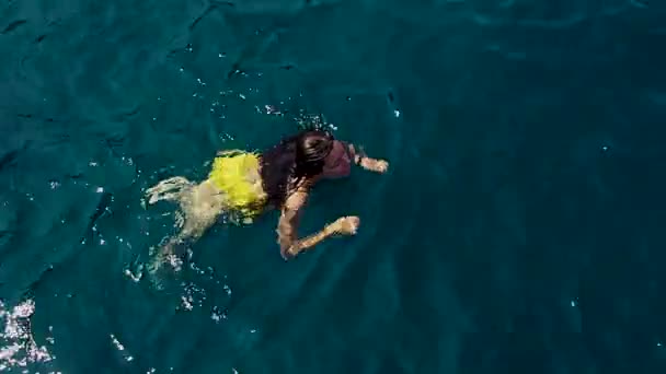 Молодая женщина в жёлтом купальнике плавает в глубине . — стоковое видео