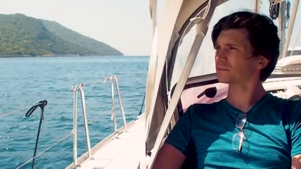 在海上休息，在游艇上乘船旅行。 一个穿蓝色T恤的年轻人 — 图库视频影像