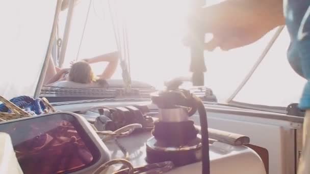 Boat trip on a yacht under sail, male yachtsman winds a rope on a winch — 비디오