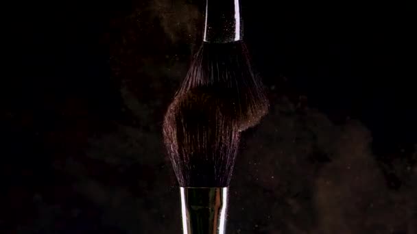 Two Soft cosmetic brushes release a cloud of colored smoke from bright eyeshadow and powder, — Stock Video