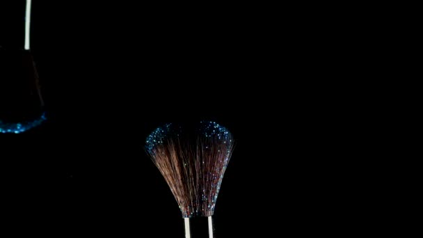 Two makeup brushes with bright eye shadow. Glitter and shadows scatter in the air — Stock Video
