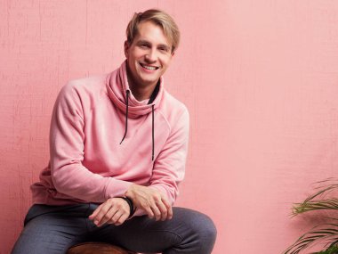 Mutlu ve güler yüzlü genç adam kameraya bakıyor, gerçek duygularla portre çiziyor.